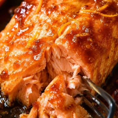 Baked salmon fillet topped with tangy orange sauce on a plate
