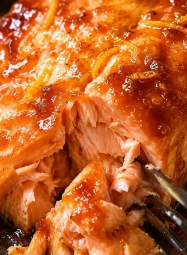 Baked salmon fillet topped with tangy orange sauce on a plate