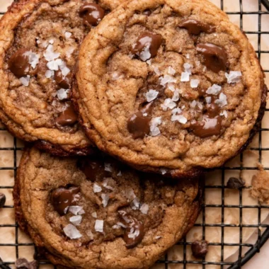 Freshly baked coffee cookies on a wooden table with coffee beans