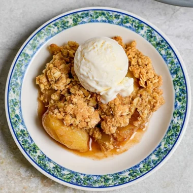 Delicious homemade apple crumble dessert topped with oats and cinnamon.