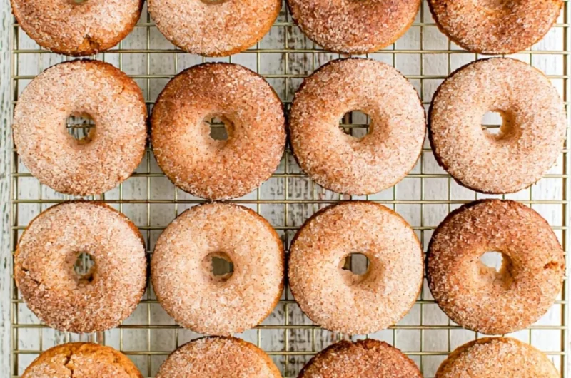Freshly baked cozy pumpkin spice donuts topped with cinnamon sugar.