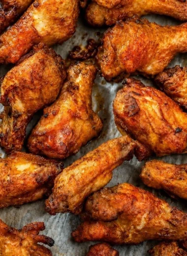 Cozy smoked chicken wings on a platter, garnished with herbs and spices.