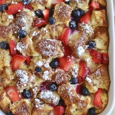 Delicious French Toast Casserole topped with syrup and berries