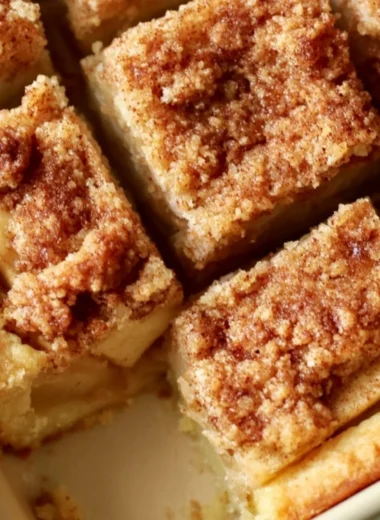 Cozy apple pie bars with a flaky crust and apple filling on a rustic wooden table