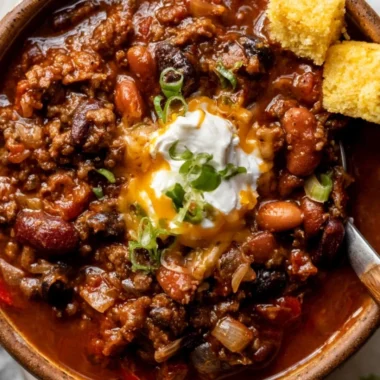 Bowl of cozy best chili recipe topped with cheese and cilantro.