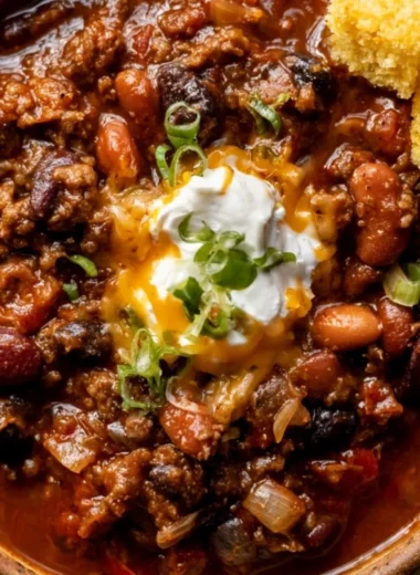 Bowl of cozy best chili recipe topped with cheese and cilantro.