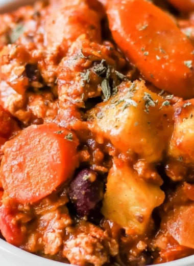 Bowl of cozy Turkey Apple Chili topped with fresh herbs and spices