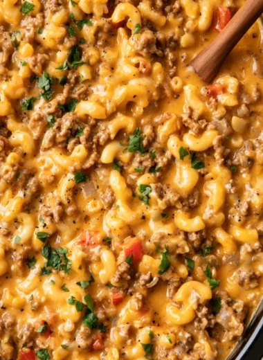 Slow cooker hamburger helper in a bowl with vegetables and cheese