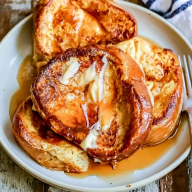 Delicious slice of French toast topped with fresh berries and syrup