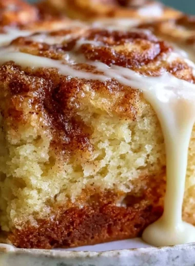 Delicious Cinnabon Cinnamon Roll Cake topped with creamy icing and cinnamon