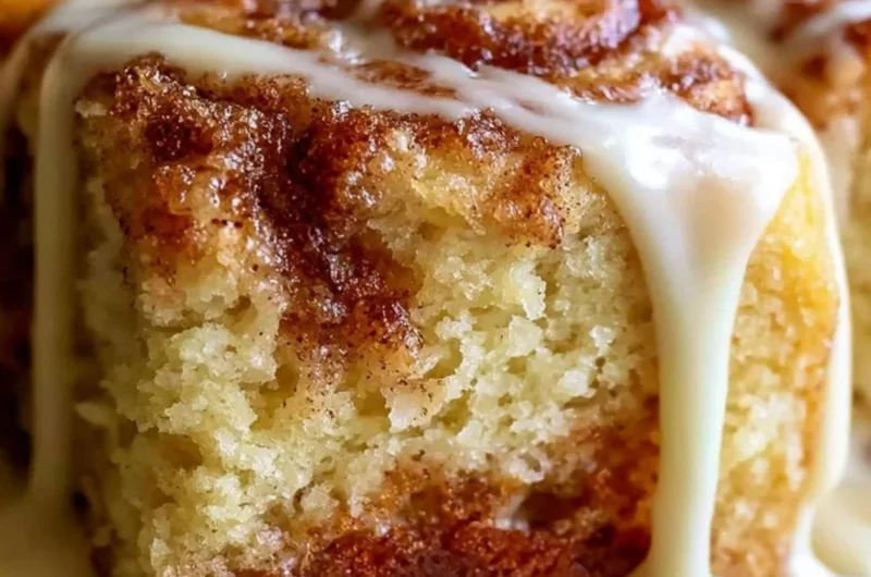 Delicious Cinnabon Cinnamon Roll Cake topped with creamy icing and cinnamon