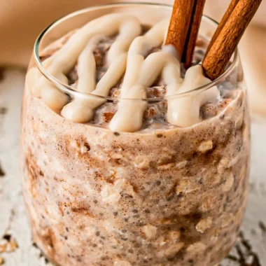 Bowl of cinnamon roll overnight oats topped with cinnamon and nuts