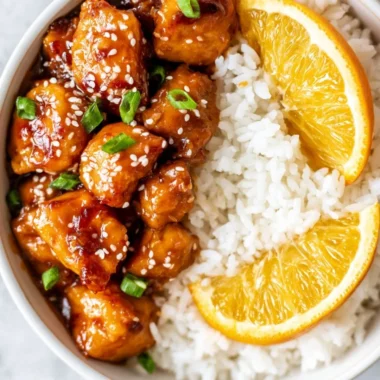 Healthy homemade orange chicken served in a bowl with vegetables.