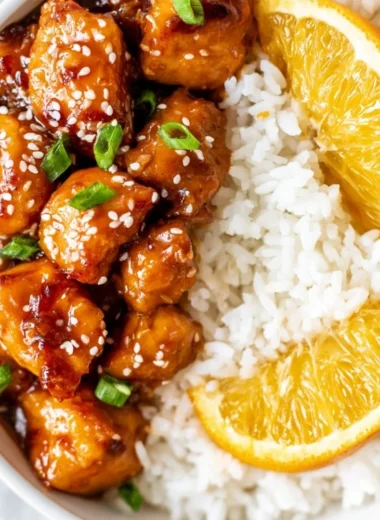 Healthy homemade orange chicken served in a bowl with vegetables.