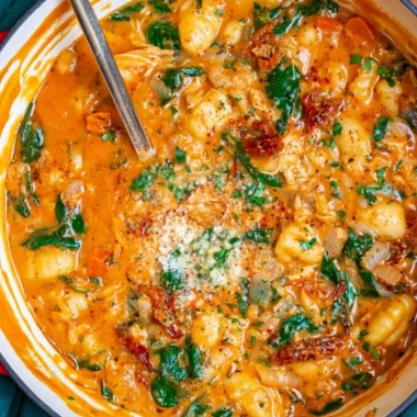 Bowl of Italian Chicken Gnocchi Soup garnished with herbs and vegetables