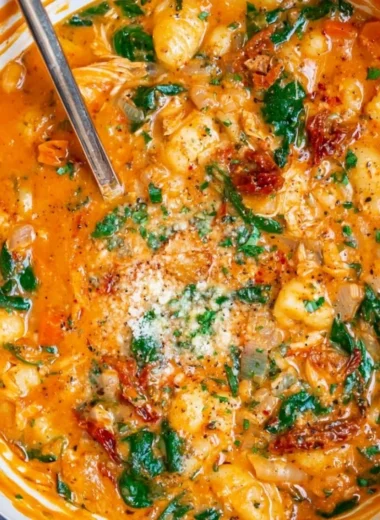 Bowl of Italian Chicken Gnocchi Soup garnished with herbs and vegetables