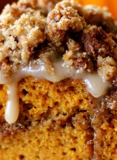 Pumpkin coffee cake with streusel topping on a rustic wooden table