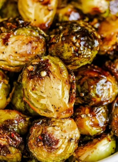 Roasted Brussels Sprouts drizzled with Honey Balsamic Sauce on a serving plate